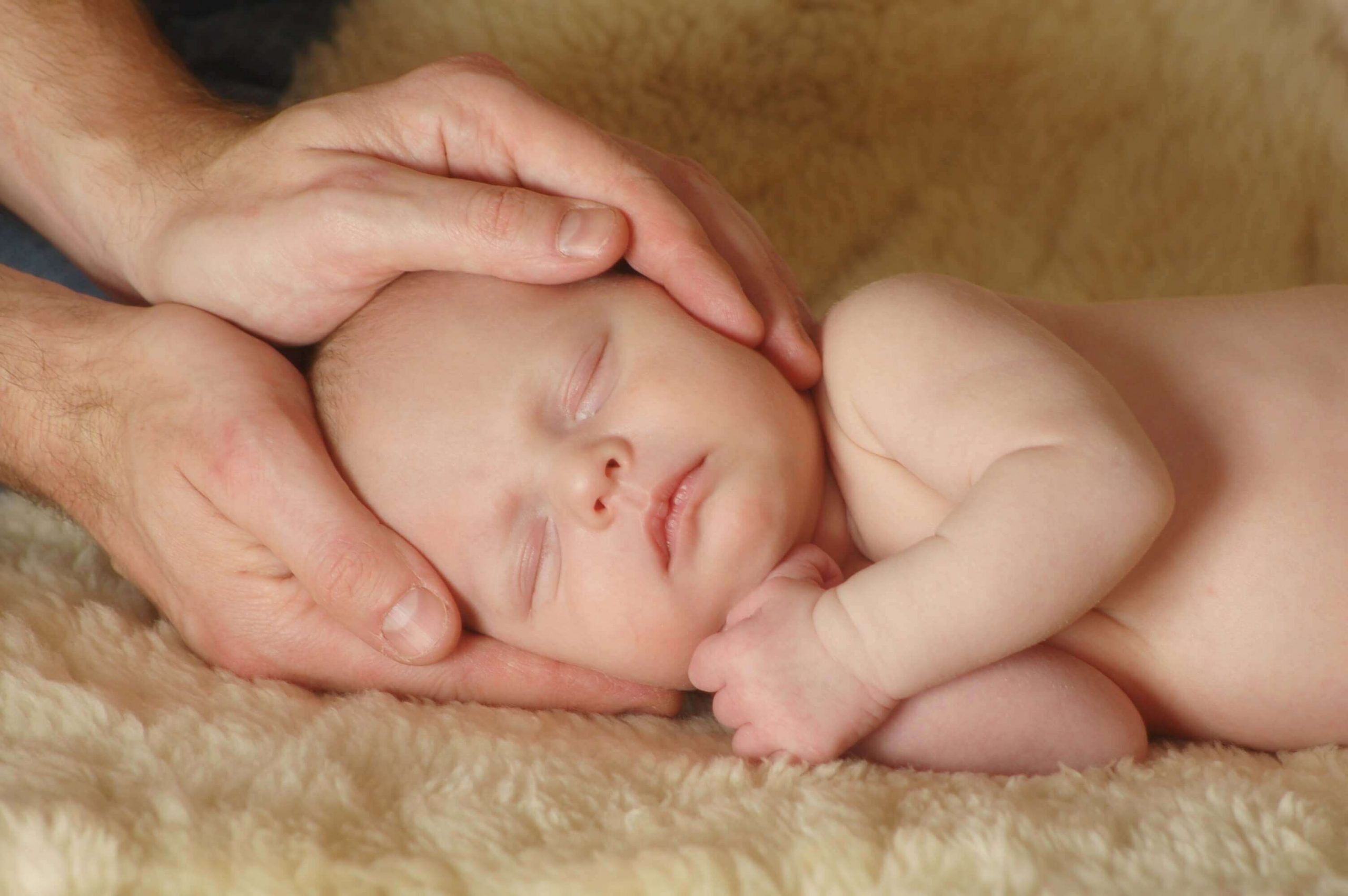 An osteopathic doctor giving message to a newborn